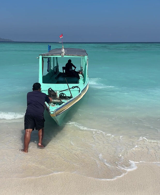 Traditionelles Glasbodenboot auf den Gili am Strand