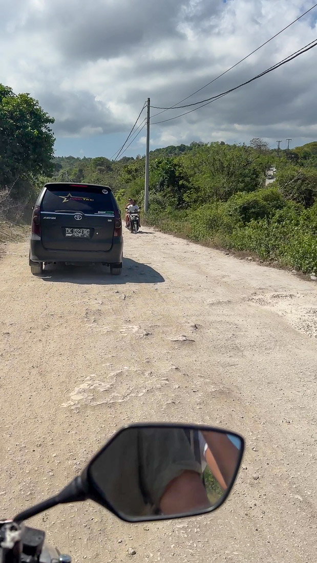 Straße mit Schlaglöchern auf dem Weg zum Broken Beach Nusa Penida