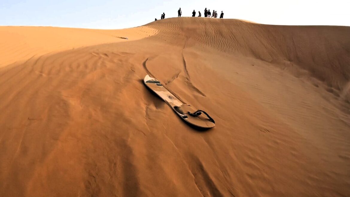 Dubai Outdoor-Aktivitäten Sandboarding vor Düne bei Wüstensafari