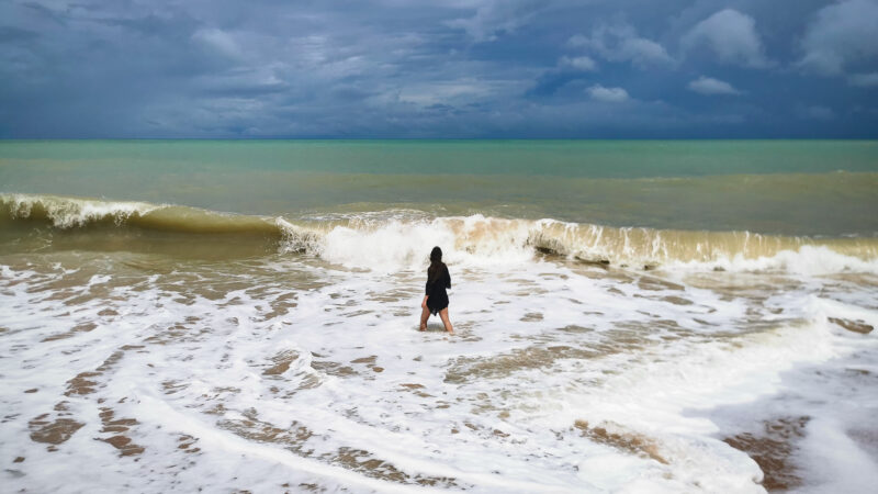 Khao Lak Meer mit hohen Wellen zur Regenzeit Regenzeit und Julia im Wasser